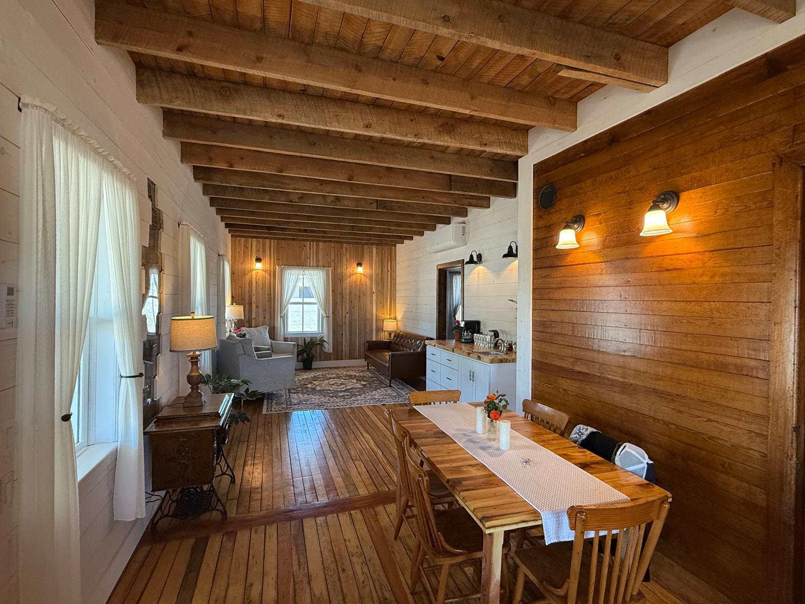 The restored interior of The Mennonite House 1922 showing original timber beams and century-old wood floors